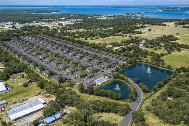 Bird's-eye 3D exterior render of a residential apartment development with roads and landscaping